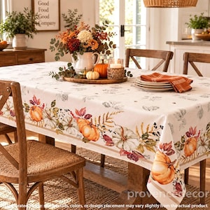 May include: A rectangular tablecloth featuring a seasonal autumn print with orange pumpkins, brown and red fall leaves, and sprigs of berries on a light cream background. The pattern is arranged in a decorative border along the edges.
