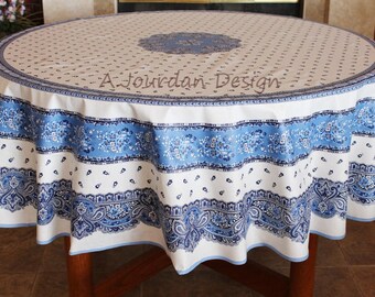 May include: A white and blue round tablecloth with a paisley pattern. The tablecloth has a blue border with a white and blue floral design. The tablecloth is made of cotton and is 100% machine washable.