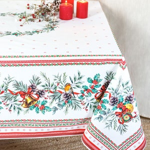 May include: White tablecloth with a red and green border and a festive winter scene featuring a robin, pine cones, holly, and bells.