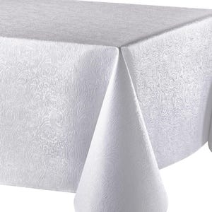 May include: A white tablecloth with a subtle, embossed floral pattern. The fabric drapes over a table, showcasing the texture and design. The tablecloth is a solid white color, suitable for formal or casual dining.