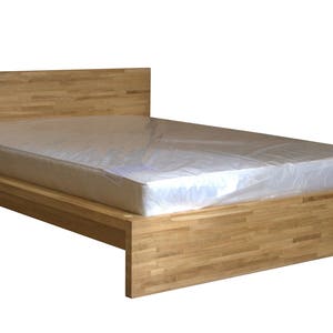May include: A wooden bed frame with a light wood finish. The bed frame has a simple design with a headboard and footboard. The bed frame is made of solid wood and has a natural wood grain.