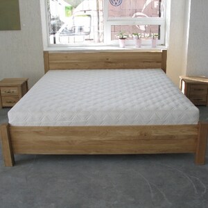 Pu&ograve; includere: Un letto con struttura in legno con un materasso bianco e due comodini in legno abbinati. La struttura del letto &egrave; in legno naturale con una finitura marrone chiaro. I comodini hanno due cassetti ciascuno.