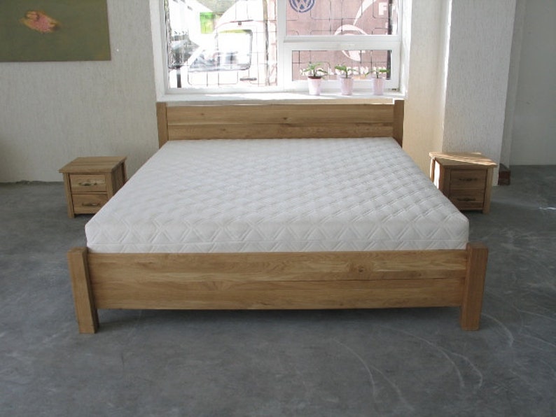 Pu&ograve; includere: Un letto con struttura in legno con un materasso bianco e due comodini in legno abbinati. La struttura del letto &egrave; in legno naturale con una finitura marrone chiaro. I comodini hanno due cassetti ciascuno.