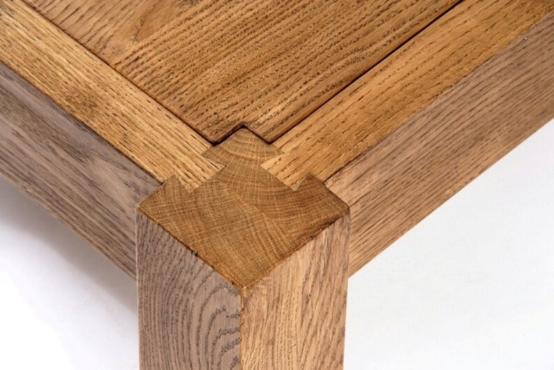 May include: Close-up of a wooden table leg with a mortise and tenon joint. The joint is made of two pieces of wood that are joined together with a groove and a tongue.