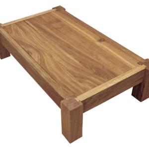 May include: A rectangular wooden coffee table with a natural wood finish and a simple design. The table has a thick top and four sturdy legs.