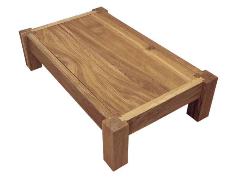 May include: A rectangular wooden coffee table with a natural wood finish and a simple design. The table has a thick top and four sturdy legs.
