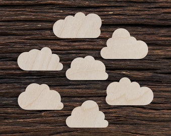 Peut inclure: Sept formes de nuages en bois blanc disposées sur un fond de bois brun foncé.