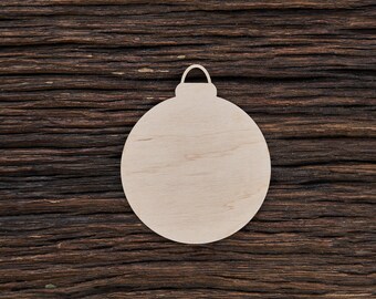 May include: A plain, round, wooden ornament with a loop at the top. The ornament is light brown and is sitting on a dark brown wooden surface.