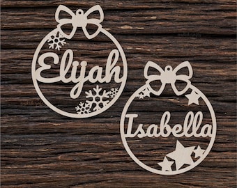 May include: Two wooden Christmas ornaments with names "Elijah" and "Isabella" cut out. Each ornament has a bow and snowflake or star designs.