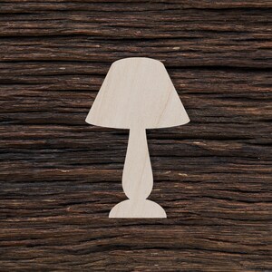 May include: A white wooden lamp silhouette against a dark brown wood background.