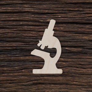 Puede incluir: Un recorte de madera blanco de un microscopio sobre un fondo de madera marrón oscuro.