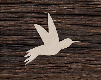 May include: A white wooden hummingbird cutout on a dark brown wood background.
