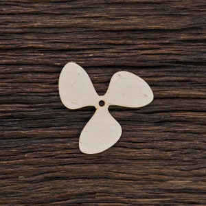 May include: A wooden propeller shape cut out against a dark brown wood background.