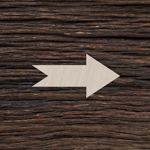 May include: A white wooden arrow pointing to the right, mounted on a dark brown wooden surface.