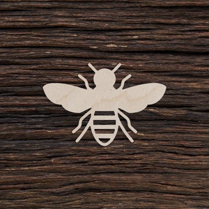 May include: A white wooden cutout of a bee on a dark brown wooden background.