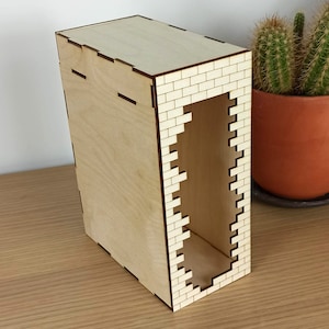 May include: A wooden box with a brick pattern on the front and sides. The box has a rectangular opening on the front.