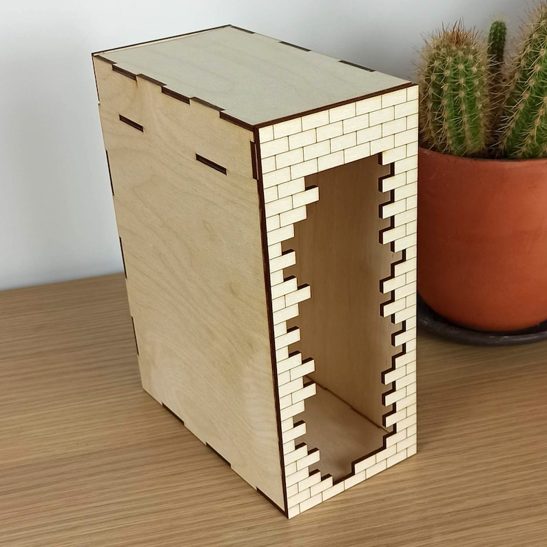 May include: A wooden box with a brick pattern on the front and sides. The box has a rectangular opening on the front.