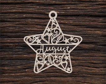 Puede incluir: Un adorno de madera en forma de estrella con intrincados recortes, incluyendo corazones, estrellas y hojas. La palabra "Agosto" está escrita en el centro de la estrella.