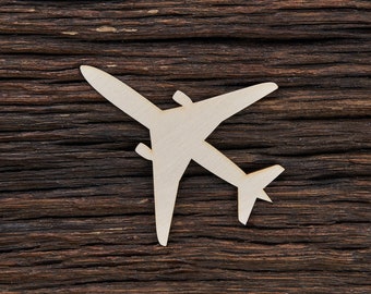 May include: A light-colored wooden airplane cutout with wings and a tail fin. The airplane is set against a dark brown, textured wooden background. The cutout is a simple, flat design, suitable for crafts or decor.