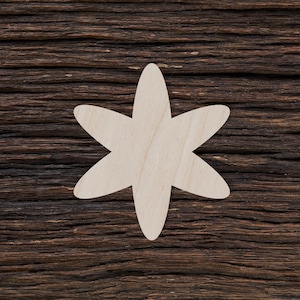 May include: A white wooden star-shaped cutout on a dark brown wood background.