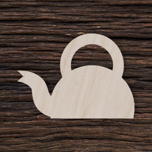 May include: A wooden cutout of a teapot on a dark brown wood background.