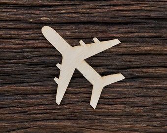 May include: A light-colored wooden airplane cutout with wings and a tail, set against a dark brown, textured wooden background. The airplane is a simple, flat design, perfect for crafts or decor.