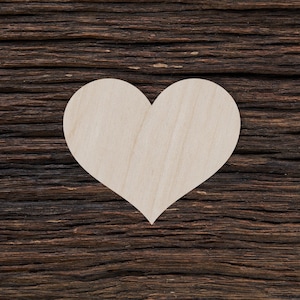 May include: A white wooden heart shape on a dark brown wood background.