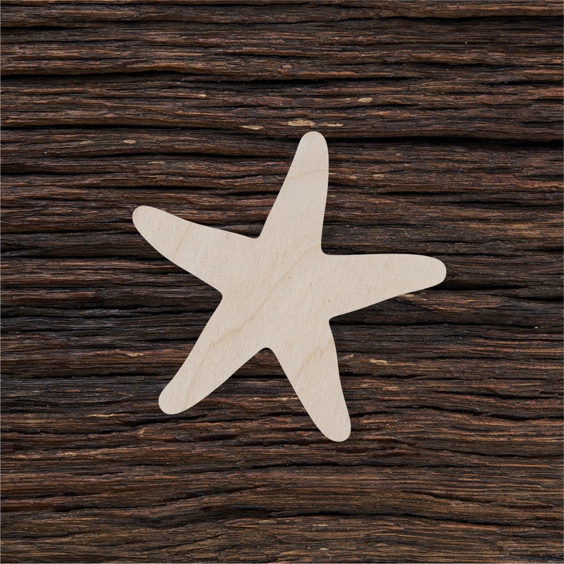 Pode incluir: Um recorte de estrela do mar de madeira branca sobre um fundo de madeira marrom escuro.