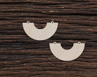 May include: Two unfinished wooden half-circle shapes with holes for hanging. The shapes are on a dark brown wooden background.