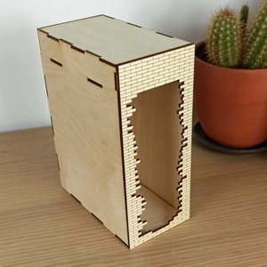 May include: A wooden box with a brick pattern on the front. The box has a rectangular opening in the front, creating a shelf inside.