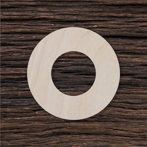 May include: A white wooden ring with a hole in the center, against a dark brown wood background.