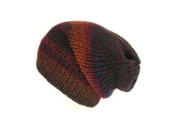 May include: A slouchy knit beanie featuring a variegated color pattern with blended tones of deep burgundy, dark brown, and hints of forest green. The hat is constructed with a ribbed texture throughout, creating a soft and flexible fabric structure.