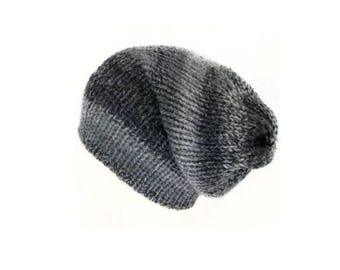 May include: A slouchy knit beanie hat featuring a variegated color pattern that transitions between shades of charcoal gray, slate gray, and black. The hat is constructed with a chunky, textured yarn weave that creates a soft, ribbed appearance.