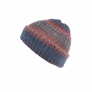 May include: A knit beanie hat featuring a variegated color pattern with blended tones of blue, red, and purple. The hat is constructed with a thick, ribbed texture and includes a wide, folded cuff at the base, creating a rounded silhouette.