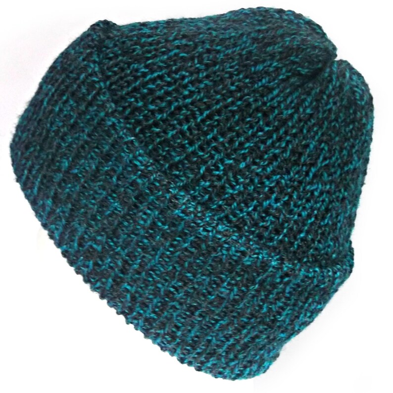 Peut inclure: Un bonnet tricot&eacute; de couleur sarcelle et noir. Le bonnet est fait d'un fil textur&eacute;, avec un bord repli&eacute;. Cet accessoire d'hiver est id&eacute;al pour les journ&eacute;es froides et mesure environ 20 cm de hauteur.