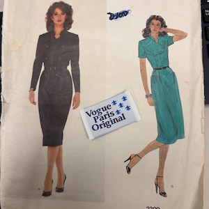 May include: Vintage Vogue Paris Original sewing pattern featuring two dress designs. The pattern includes illustrations of the dresses, one in black and the other in teal. The pattern is labeled "Pierre Balmain" and includes the number 2309.