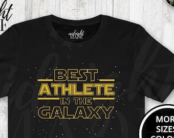 May include: Black t-shirt with a gold graphic that says "Best Athlete in the Galaxy".