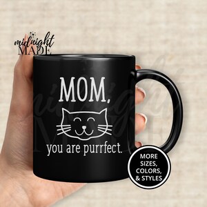 May include: Black ceramic coffee mug with a white cat illustration and the text "MOM, you are purrfect."
