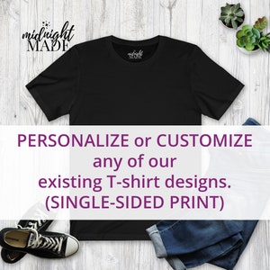 May include: Black t-shirt with the text "midnight MADE" on the front. The t-shirt is laying flat on a wooden surface with a pair of jeans and sneakers. The text "PERSONALIZE or CUSTOMIZE any of our existing T-shirt designs. (SINGLE-SIDED PRINT)" is on a white banner.
