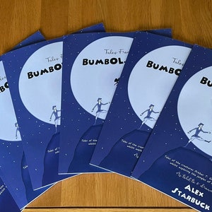 May include: Six copies of a blue children's book titled "Tales From Bumbol-Bee" by Alex Starbuck. The cover features a cartoon illustration of a girl in a blue dress jumping off a cliff with a creature flying behind her.