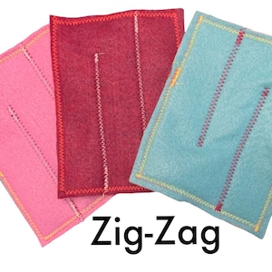 May include: Three felt squares with zig-zag stitching around the edges. The squares are pink, red, and blue. The text "Zig-Zag" is printed below the squares.