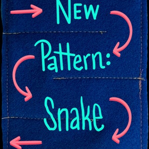 May include: A blue fabric swatch with pink arrows pointing to the text "New Pattern: Snake" written in turquoise.