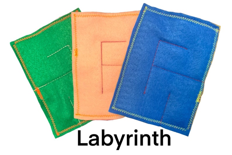 May include: Three felt squares with different colored felt and stitched lines forming a maze pattern. The squares are green, orange, and blue. The text "Labyrinth" is printed below the squares.