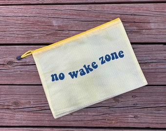 May include: A yellow mesh zippered pouch with a blue "no wake zone" text printed on it.