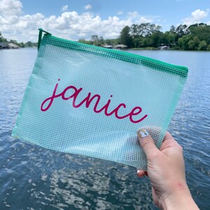 Puede incluir: Una bolsa de pl&aacute;stico transparente con cremallera verde y el nombre "janice" escrito en letras rosas.