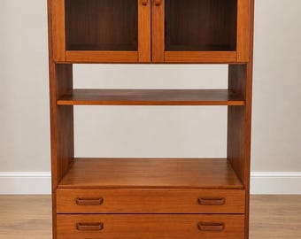 May include: A tall wooden cabinet featuring a top section with two glass-paneled doors and internal shelving, an open middle shelf, and a bottom section with four horizontal drawers, each equipped with two integrated wooden pull handles.