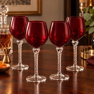 May include: A set of four wine glasses featuring deep red, translucent bowls and clear, twisted glass stems. Each glass has a wide, rounded basin and a circular base, showcasing a distinct spiral pattern within the stem design.