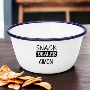 Pode incluir: Tigela de esmalte branco com borda azul. A tigela tem texto preto que diz "Snack Dealer Simon".
