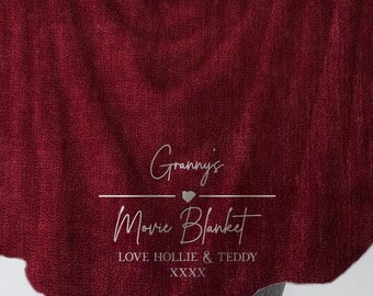 Puede incluir: Una manta roja y peluda con el texto "Granny's Movie Blanket" y "Love Hollie & Teddy XXXX" en blanco.