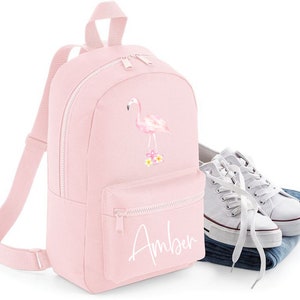 May include: Pink backpack featuring a flamingo design with the name "Amber" printed on the front.